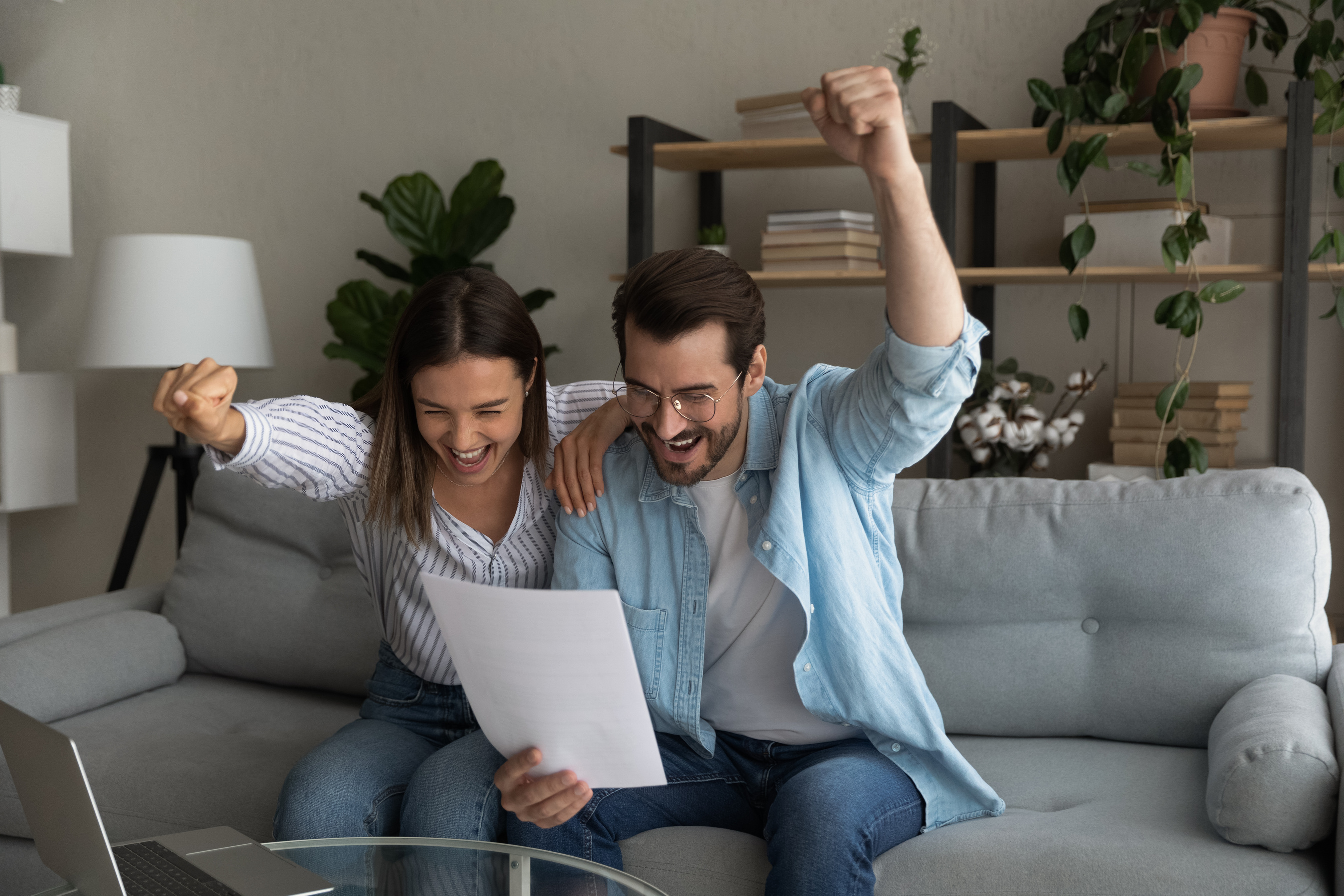 Excited young married couple getting money grant for family business